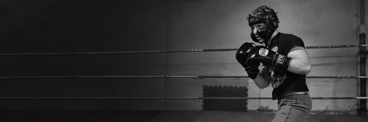 Boxer training in the ring wearing headgear and Cleto Reyes gloves